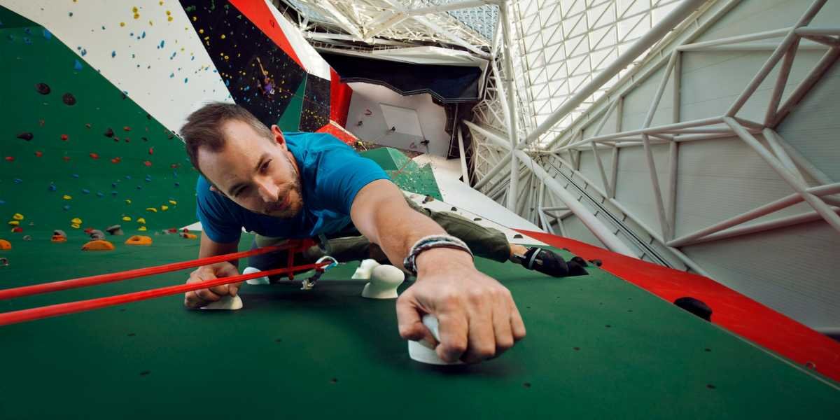 Climber tackling indoor top-rope route at CLYMB Yas Island Abu Dhabi during The SUMMYT Showdown competition