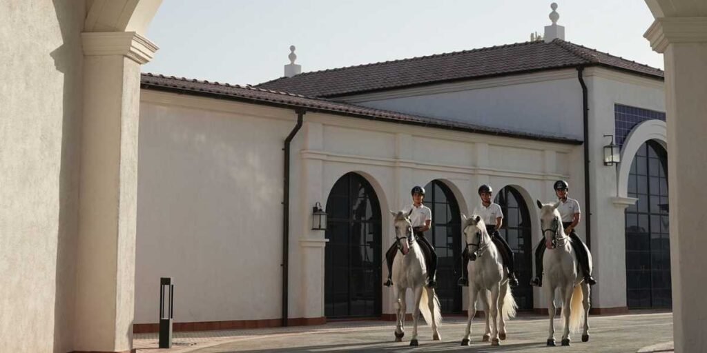 Riders trotting through the ADREA archway at the Jubail Island campus